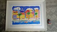 Full view of the framed colorful coastal scene print by Sally Huss with a size comparison to a spice jar.