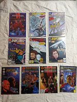 Photo showing ten bagged Star Trek comic books laid out in two rows of five on a white surface. Covers display various characters and Star Trek themes.