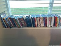 Full view of the over 50 DVDs lined up showing an extensive collection of movies and series.
