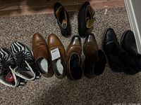 All 5 pairs of shoes arranged side-by-side on carpeted floor showing variety of styles and colors.