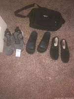 Photo showing Nike grey athletic shoes, Adidas slide sandals, Vans slip-on shoes, and plastic hangers on carpet.