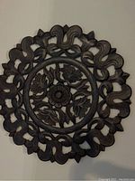 Front view of the round floral carved wall art showing the overall design and condition.