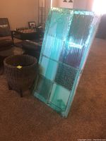 Wicker basket next to the window frame in a living room environment with furniture in background.