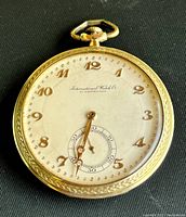 Front view showing cream enamel dial with applied gold Arabic numerals, leaf hands and sub-seconds at 6 o’clock