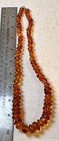 Full view of vintage Baltic amber bead necklace with a ruler showing approximate length of 10 inches.
