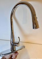 Front side view of the chrome Kohler kitchen faucet with pull-out spray and single lever handle, held upright.