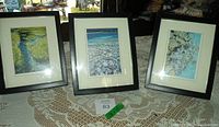 Three framed watercolor paintings displayed on a lace covered table, each signed by Margaret Vanderpas, measuring 9" x 11" in frame.