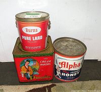 Three vintage metal tins stacked: Burns Pure Lard, Daconfee Cream Wafers, Alpha Honey. Tins have visible graphics and some wear.