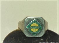 Front view of the men's school ring showing the enamel emblem with text 'Science Commercial Monklands XIC 59' in green and yellow colors on a silver toned background.