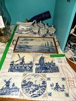 Overview of the entire lot showing gravy boat, spice jars, decorative tiles, and cobalt blue bottle.