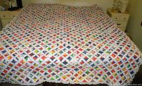 Full view of the Cathedral Window quilt spread on a bed showing overall size and color pattern.