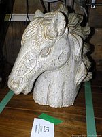 Frontal view of the pottery horse head sculpture showing detailed facial features and rough texture.