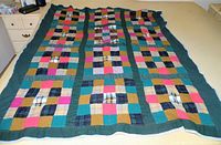 Full view of homemade patchwork quilt laid flat showing overall pattern and color arrangement.