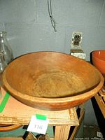 Side angle view showing the wooden dough bowl's size and wear marks on the bottom.
