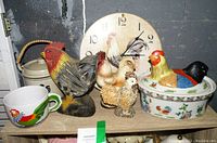 Lot overview showing ceramic mug, wooden rooster, various ceramic rooster figurines, lidded rooster dish, and wall clock with rooster image.