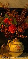 Full view of the large hand-painted pitcher vase with detailed fall floral arrangement including orange flowers and berries.