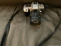 Front view of the Minolta 35mm camera showing attached lens and shoulder strap.