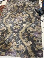 Full view of the gray botanical design rug showing floral and scroll patterns.