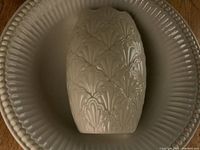Top view of turkey-shaped platter and serving bowl showing embossed design and cream color
