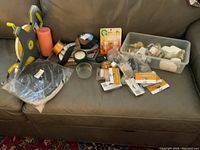 Front view of complete lot of surveyors tapes, ribbons, candle, and accessories laid out on a couch