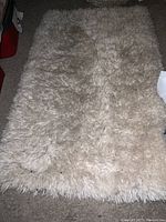 Top view of the rectangular shaggy cream-colored faux fur rug showing a plush texture.