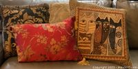 Group of assorted throw pillows on beige couch showing different colors and patterns