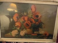 Overall image of vintage floral print with carved wood frame showing the red and orange poppies, vase, and blue lamp in background.