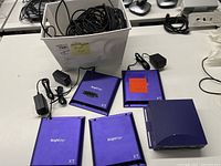 Overall view: four XT3 units, one 4K unit, box of cables, power adapters scattered on table