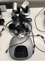 Overview of both sets: two PTZ cameras on stands, speakerphone hubs, remotes, microphone pods, cables, and power adapter.
