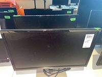 Front view showing three Dell monitors with size stickers and power cables coiled on stands.