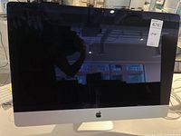 Front view of 27-inch Apple iMac powered off showing display, integrated stand and Apple logo