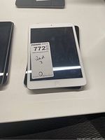Two Apple iPads stacked with white front bezel and central Home button visible on top device.