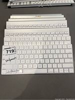 Stack of seven Apple wireless keyboards