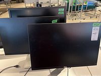 Three Dell monitors front view on table