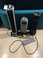 Front view of three tower ceramic heaters and Belkin power bar on floor