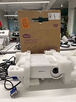Front view of BenQ projector seated in foam inserts with box behind
