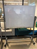 Full front view of whiteboard on metal frame with casters indoors.