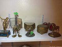 Overview image of all items on a shelf including figurines, boxes and frames.