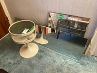 Side table and large mirror displayed together on carpeted floor