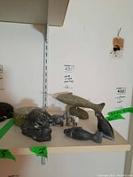 All items on shelf: box, wolf head, two small animals, fish, narwhal, seal