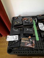 Overview of multiple black plastic cases topped with various Veritas miniature tools including bench plane box, block planes, marking gauge, router and plow planes