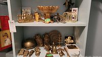 Overview of two shelves showing brass and silver-tone decor pieces