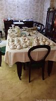 Wide view of dining table surrounded by chairs showing overall style and number