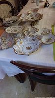 Multiple porcelain serving pieces arranged on table: bowls, divided dishes, candy dishes.