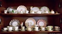 Two-shelf overview showing assorted plates, cups and saucers