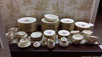 Full layout of plated service with stacked plates, cups, saucers and serving pieces