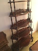 Full view of the shelving unit showing all five shelves, decorative backs, and turned posts