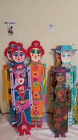 Five colorful painted wooden figurine decorations lined together, showing varied patterns and colors, highlighted heart and floral motifs.