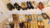 All shoes laid out on carpet and shelves, showing various styles and brands including Michael Kors and 9 West.