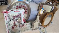 Group of various mirrors of different sizes and frames including round metal, white wooden with pink ribbon, beveled glass framed mirrors, and wood framed mirrors with decorative carvings.